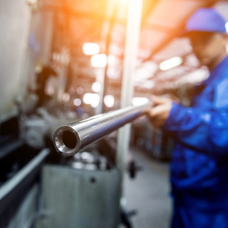 Worker checking metal pipes
